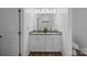 Bathroom featuring a double sink vanity with granite countertops and wood look flooring at 14532 E Rocky River Rd, Davidson, NC 28036