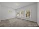 Spacious bedroom with neutral carpeting, three large windows for natural lighting, and a comfortable ambiance at 14532 E Rocky River Rd, Davidson, NC 28036