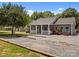 Inviting home featuring gravel driveway, a charming front porch with a white picket fence, and fresh landscaping at 14532 E Rocky River Rd, Davidson, NC 28036