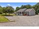 Inviting exterior highlighting gravel driveway, a charming porch with a white picket fence, and fresh landscaping at 14532 E Rocky River Rd, Davidson, NC 28036