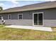 Home exterior featuring gray siding and access to concrete patio at 14532 E Rocky River Rd, Davidson, NC 28036