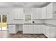 Bright kitchen featuring white cabinets, sleek countertops, and a view of the backyard at 14532 E Rocky River Rd, Davidson, NC 28036