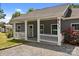 Inviting porch featuring white picket fence, gray siding, colorful flowers, and a gravel driveway at 14532 E Rocky River Rd, Davidson, NC 28036