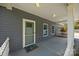 Welcoming porch featuring gray siding, white trim, and a view of the well-manicured front yard at 14532 E Rocky River Rd, Davidson, NC 28036