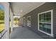 Inviting porch features gray siding, white columns, and a glimpse of the landscaped yard at 14532 E Rocky River Rd, Davidson, NC 28036