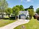Charming home featuring a well-maintained lawn, mature trees, and a private driveway on a sunny day at 1506 Crestdale Rd, Rock Hill, SC 29732