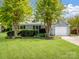 Beautiful single Gathering home features a well-manicured lawn, fresh landscaping, and attached garage at 1506 Crestdale Rd, Rock Hill, SC 29732