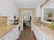 Galley kitchen with white cabinets and appliances, adjacent to living room for easy access at 1506 Crestdale Rd, Rock Hill, SC 29732