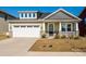 Charming home exterior with a two-car garage, a covered front porch, and manicured landscaping at 1516 Laggan Ln, Indian Trail, NC 28079