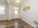 Bright foyer featuring wood-look floors and an elegant decorative wall piece creating a welcoming atmosphere at 1516 Laggan Ln, Indian Trail, NC 28079