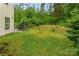 Lush, private backyard with green lawns and surrounding trees, offering a serene outdoor space at 16219 Long Talon Way, Charlotte, NC 28273