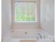 Close-up view of a well-lit bathtub with chrome fixtures and a window with blinds at 16219 Long Talon Way, Charlotte, NC 28273