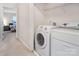 Laundry area with modern white washer and dryer, with open doorway to bedroom at 16219 Long Talon Way, Charlotte, NC 28273