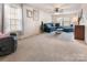 Bright living room with a plush blue sectional sofa, neutral walls, and soft carpeting at 16219 Long Talon Way, Charlotte, NC 28273