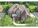 A well-manicured lawn and mature trees frame the home's exterior, showcasing its curb appeal from above at 2001 Arundale Ln, Matthews, NC 28104