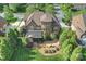 Aerial view of a stately home with a large backyard, complemented by mature trees, a screened porch, and solar panels at 2001 Arundale Ln, Matthews, NC 28104