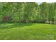 A vast, meticulously maintained lawn offers a picturesque view of the surrounding trees and landscaping at 2001 Arundale Ln, Matthews, NC 28104