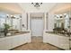 Elegant bathroom with dual vanities, decorative columns, and a central cabinet at 2001 Arundale Ln, Matthews, NC 28104