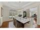 Elegant dining room with a marble table, modern chandelier, and an open view of a piano room at 2001 Arundale Ln, Matthews, NC 28104