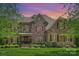 Charming brick and stone home featuring manicured lawn and lush landscaping in a sought-after neighborhood at 2001 Arundale Ln, Matthews, NC 28104