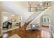 Bright foyer with grand staircase, hardwood floors, and views to piano room and living room at 2001 Arundale Ln, Matthews, NC 28104