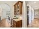 Hallway featuring a built-in bar with wine cooler and cabinet storage, leading to a dining room with an arched doorway at 2001 Arundale Ln, Matthews, NC 28104