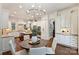 Bright kitchen with white cabinets, a large island, modern appliances, and an adjacent breakfast nook at 2001 Arundale Ln, Matthews, NC 28104
