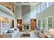 Spacious living room with a stone fireplace, built-in shelving, and large windows providing ample natural light at 2001 Arundale Ln, Matthews, NC 28104