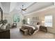 Relaxing main bedroom with tray ceilings, carpet floors, and a seating area near a large window at 2001 Arundale Ln, Matthews, NC 28104