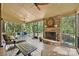 Spacious screened porch with a stone fireplace, ceiling fans, and comfortable seating, overlooking the lush backyard at 2001 Arundale Ln, Matthews, NC 28104