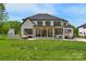 Back exterior view of a two-story home with a covered patio and an outdoor fireplace in the backyard at 2165 Country Club Rd, Lincolnton, NC 28092