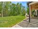 Spacious backyard featuring a lush lawn, mature trees, and an outdoor fireplace with a seating area at 2165 Country Club Rd, Lincolnton, NC 28092