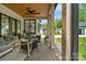 Stylish covered patio with comfortable seating, ceiling fan, and a view of the backyard and detached garage at 2165 Country Club Rd, Lincolnton, NC 28092