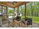 Cozy covered patio with ample seating, a ceiling fan, and a view of the detached garage and lush backyard at 2165 Country Club Rd, Lincolnton, NC 28092