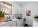 Well-equipped laundry room with washer, dryer, sink, and ample cabinet space at 2165 Country Club Rd, Lincolnton, NC 28092