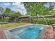 Outdoor pool with fountain features, pergola, patio, brick border, and a well-maintained garden at 2229 Kenmore Ave, Charlotte, NC 28204