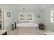 Luxurious bathroom featuring a freestanding soaking tub, white tile flooring, and window views at 2229 Kenmore Ave, Charlotte, NC 28204