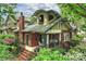 Charming brick home with a covered front porch and lush landscaping, surrounded by mature trees, in a desirable neighborhood at 2229 Kenmore Ave, Charlotte, NC 28204
