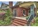 Charming front porch with brick stairs, iron railings, and comfortable seating, offering a relaxing outdoor space with neighborhood views at 2229 Kenmore Ave, Charlotte, NC 28204