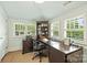 Bright office space with a large desk, built-in bookcase, and natural light from the windows at 2229 Kenmore Ave, Charlotte, NC 28204
