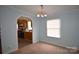 Cozy dining area leading into kitchen, with hanging chandelier and natural light at 234 Olin Loop, Olin, NC 28660