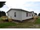 The rear exterior features a side door, a wooden deck and brick foundation at 234 Olin Loop, Olin, NC 28660