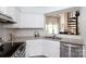 Well-lit kitchen features white cabinets, stainless steel appliances, and an open view to the living room at 2504 Stradbrook Dr # B, Charlotte, NC 28210