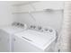 Well-equipped laundry area with white washer and dryer, and convenient shelving for organized storage at 2504 Stradbrook Dr # B, Charlotte, NC 28210