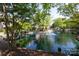 Beautiful view of a pond with fountain surrounded by lush trees and landscaping at 2504 Stradbrook Dr # B, Charlotte, NC 28210