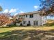 Large, grassy backyard with a white two-story house featuring a walkout basement at 2701 N Sharon Amity Rd, Charlotte, NC 28205