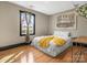 Bright bedroom with hardwood floors, an American flag, and natural light at 2701 N Sharon Amity Rd, Charlotte, NC 28205