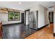 Bright kitchen area featuring stainless steel refrigerator, black-trimmed window and hardwood floors at 2701 N Sharon Amity Rd, Charlotte, NC 28205