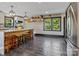Kitchen with an island, wood stools, stainless appliances, modern lighting, and open shelving at 2701 N Sharon Amity Rd, Charlotte, NC 28205