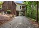 Brick home with covered boat storage underneath, steps leading up to deck, lush greenery at 32060A Flint Ridge Rd, Albemarle, NC 28001